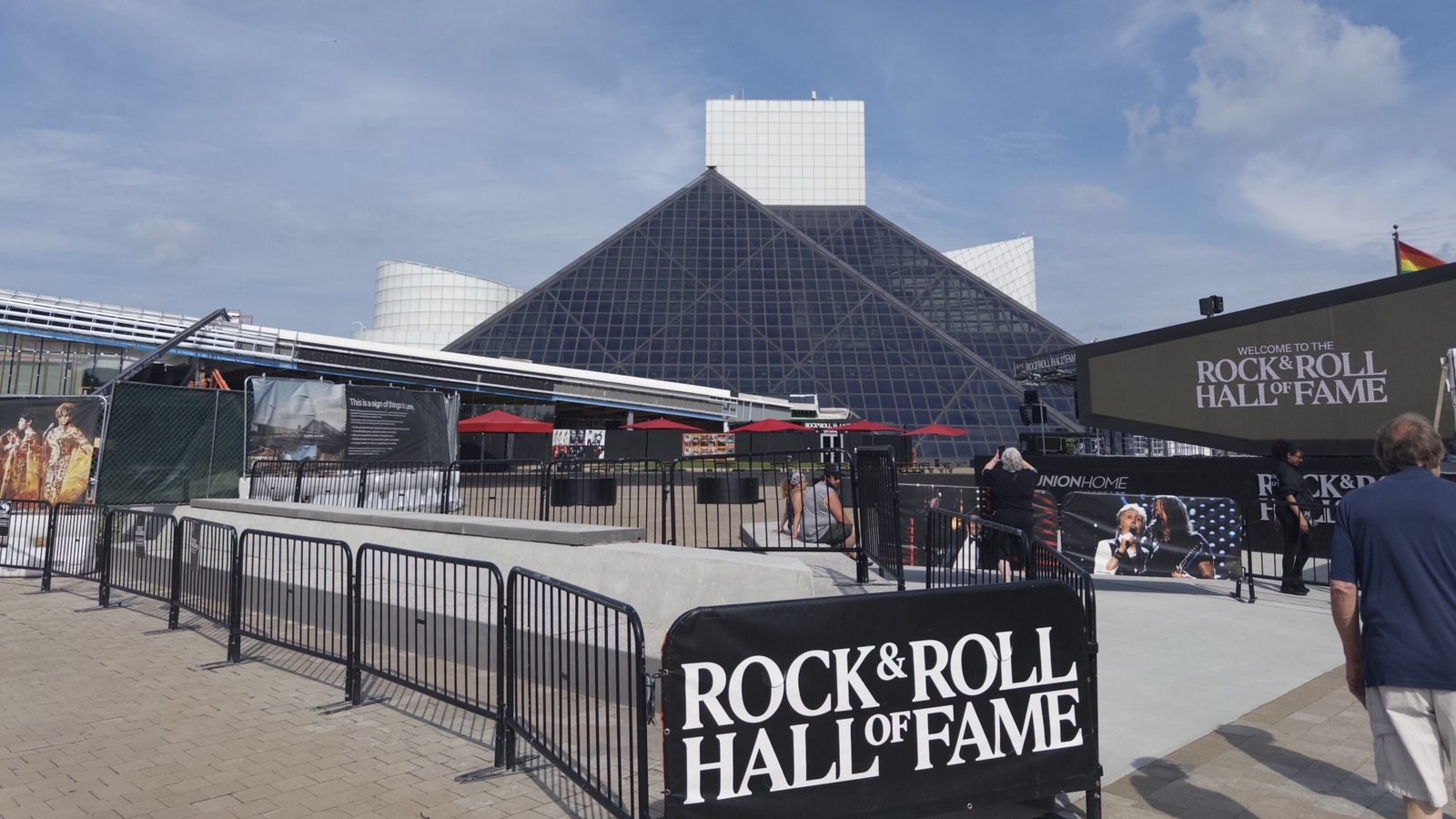 青空の下に建つRock & Roll Hall of Fame。下部に「ROCK & ROLL HALL OF FAME」の看板が写る