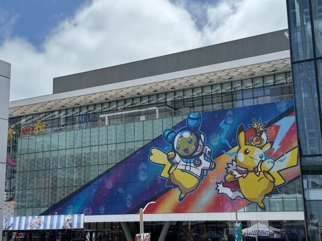 WCS会場Moscone Centerの外壁全面を覆う巨大ミューラル。宇宙服を着たキャラクターと、王冠をかぶったキャプテン姿のピカチュウが描かれ、左端に「Pokémon XP」のロゴがある
