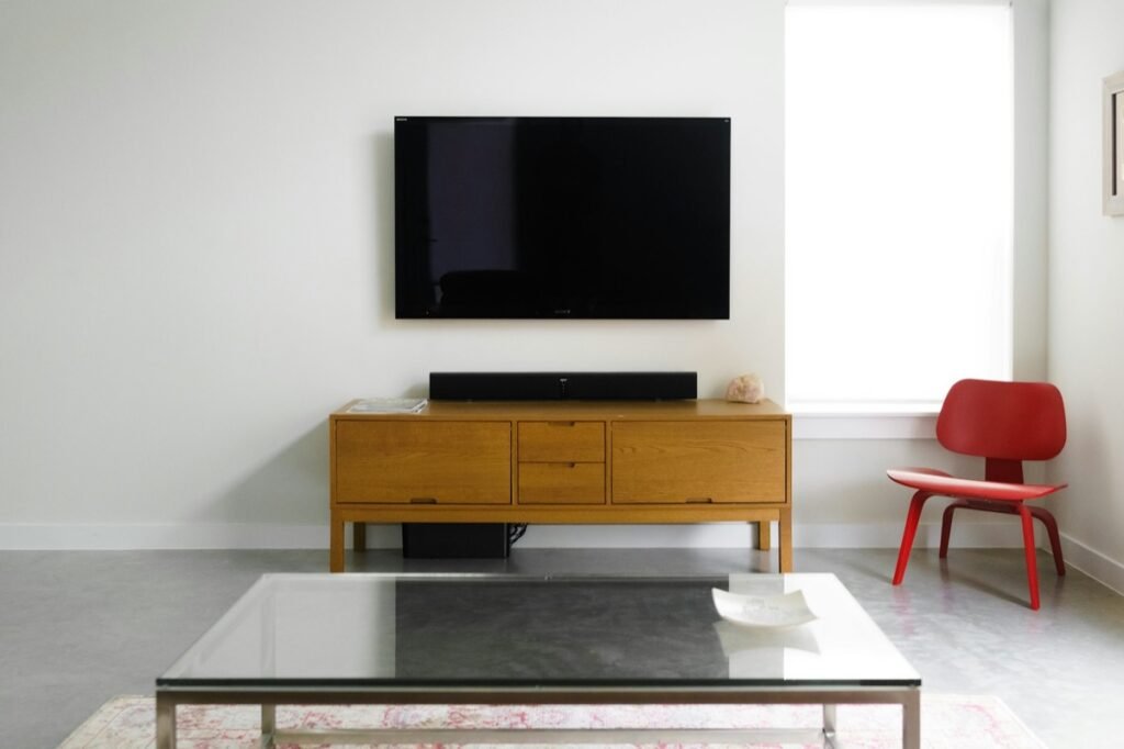 白い壁に取り付けられた、電源が入っていないテレビ。新型を待つ落ち着かない気持ちを表すイメージ写真