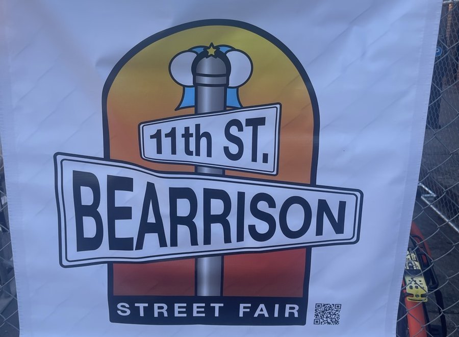 金網に掛けられた「11th ST. BEARRISON STREET FAIR」のロゴ入りバナー